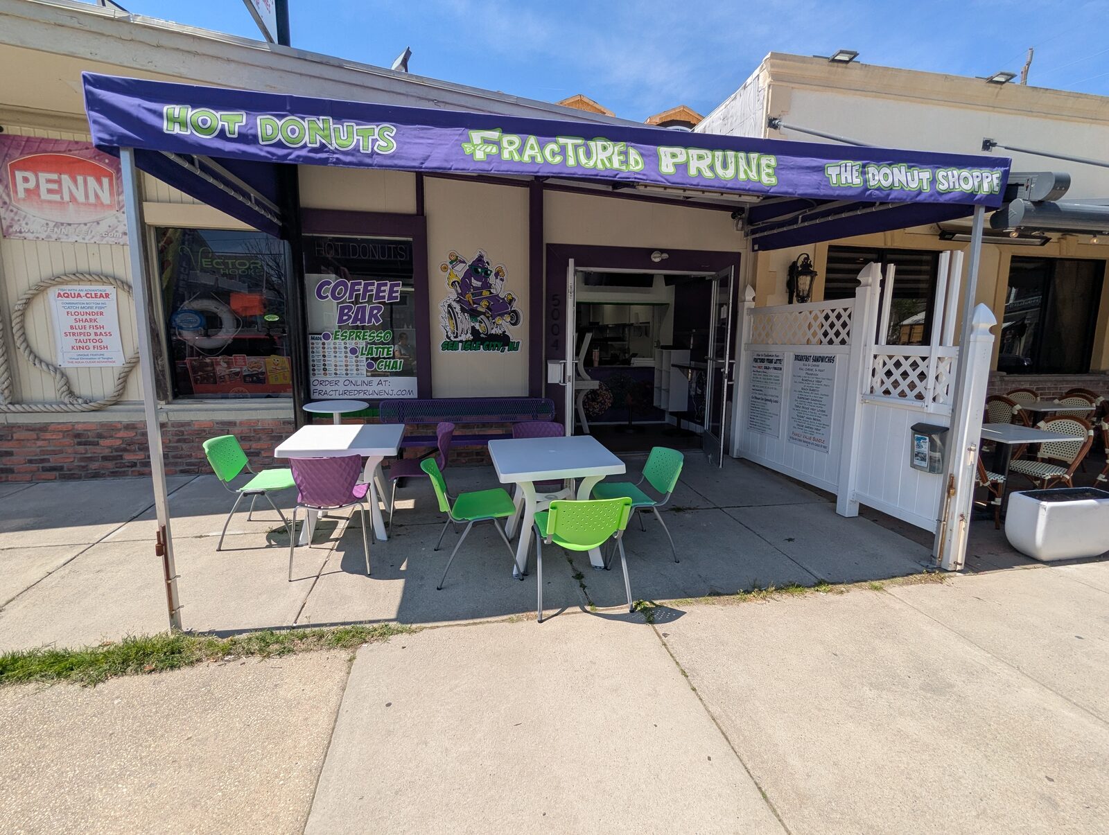 Fractured Prune Donuts storefront at 5004 Landis Ave, Sea Isle City NJ with purple awning and outdoor seating